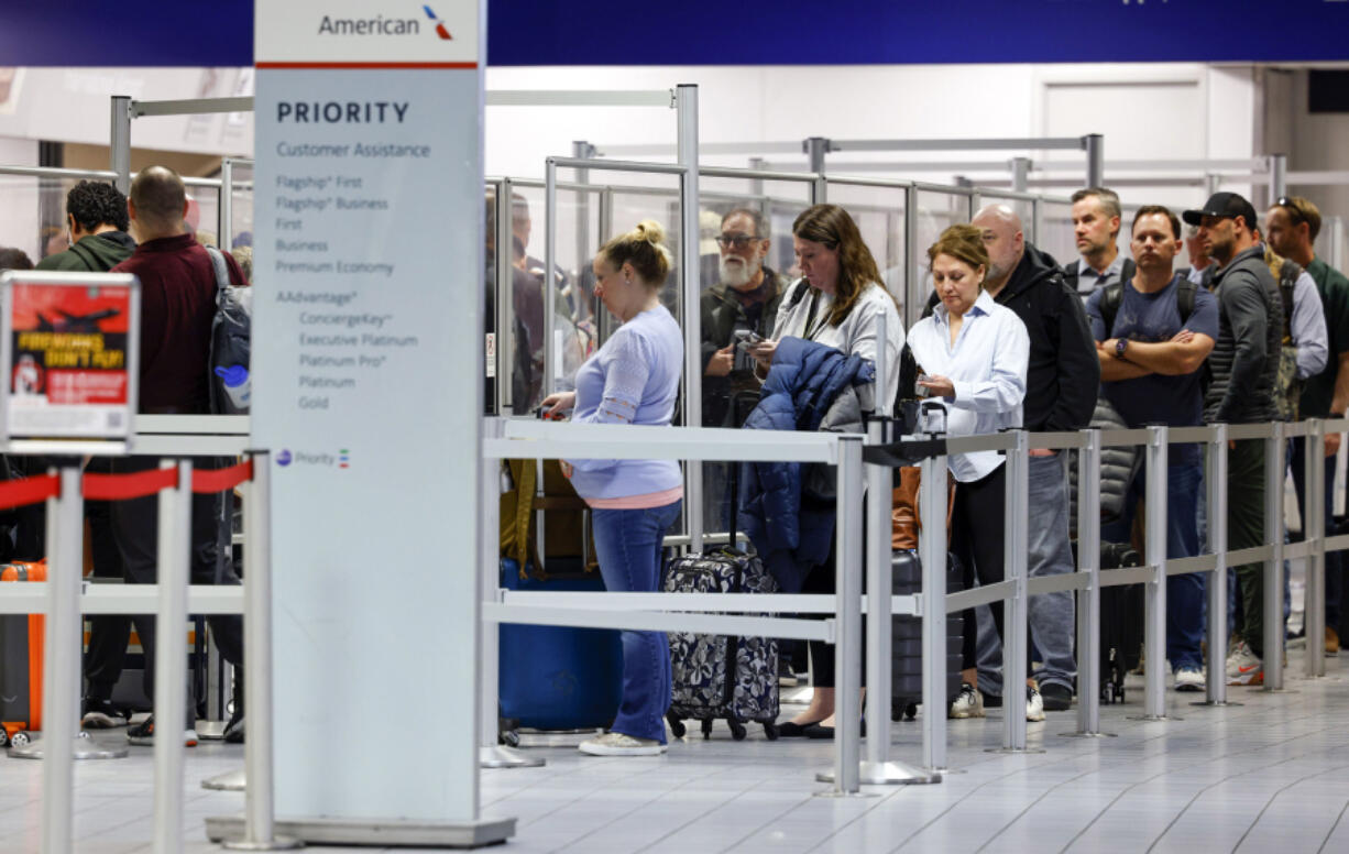 Passengers wait in line at a TSA security checkpoint inside Terminal C at DFW International Airport, Wednesday, March 1, 2023.