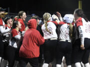 Union players surround teammate Ella Berfanger at home plate after the junior hit a solo home run in the fourth inning against Battle Ground to propel the Titans to a 1-0 victory on Wednesday, March 29, 2023, at Union High School.