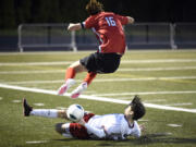 Union’s Ivan Cheburakov slides in for a tackle against JP Warnell of Camas during a 4A GSHL boys soccer game on Thursday, March 30, 2023, at Doc Harris Stadium in Camas. Camas won 2-1 thanks to two second-half goals, the last on a free kick by Warnell.