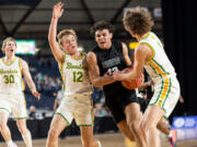 Union senior forward Yanni Fassilis drives against Richland junior guard Josh Woodard and Richland junior forward Lucas Westerfield during a Class 4A State boys basketball game on Wednesday, March 1, 2023, at the Tacoma Dome.