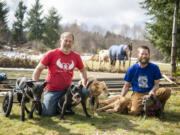 Angels with Misplaced Wings animal sanctuary founders Jeff Evans, left, and Michael Allen, pose with dogs and farm animals at Angels with Misplaced Wings Sanctuary in Amboy.