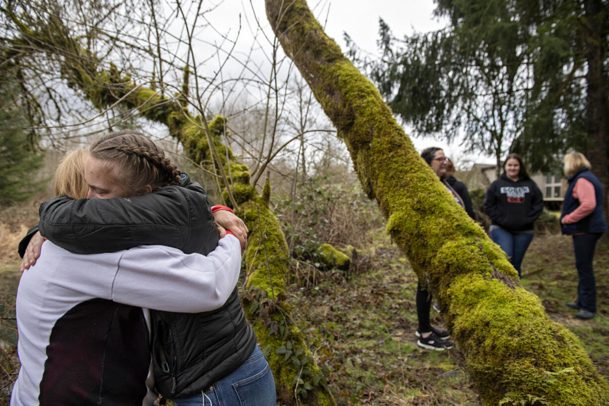 Grace Lodge house manager Rachel Sterling, left in white coat, embraces former resident Jasmine Jackson as they join other women on a walk around the property. XChange Recovery was recently told it needs to move out of Grace Lodge by the end of April due to rezoning, though the Clark County Council has requested more research on the possibility of rezoning or grandfathering to allow the women to stay.