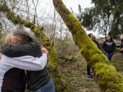 Grace Lodge house manager Rachel Sterling, left in white coat, embraces former resident Jasmine Jackson as they join other women on a walk around the property. XChange Recovery was recently told it needs to move out of Grace Lodge by the end of April due to rezoning, though the Clark County Council has requested more research on the possibility of rezoning or grandfathering to allow the women to stay.