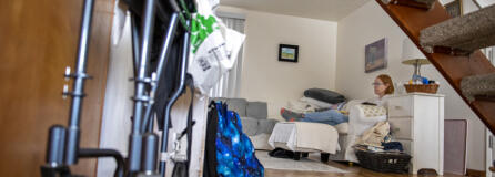 A wheelchair is pictured underneath the stairs as Melissa Worlein, who got coronavirus back in August and has since been struggling with long COVID, takes a break in between chores at her Vancouver home Tuesday afternoon, March 14, 2023.