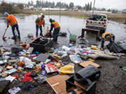 Workers from Share's Talkin' Trash program clean up a pile of rubbish Monday afternoon in Vancouver's Lincoln neighborhood. The program's staff removed 267 tons of trash last year from sites around Vancouver.