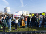 Cascade Middle School students wave signs Friday, March 17, 2023, from inside the school fence along 18th Avenue. The student-organized protest was in response to a proposal to eliminate several positions across schools in the Evergreen School District in order to make up a $19 million budget shortfall for the 2023-24 school year.