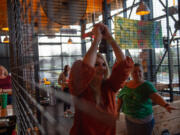 Bethany Seegert of Vancouver, left, gets pointers from ax matron Darbi Johnson of Portland at Celtic Axe Throwers' lanes inside Hopworks Urban Brewery in Vancouver.