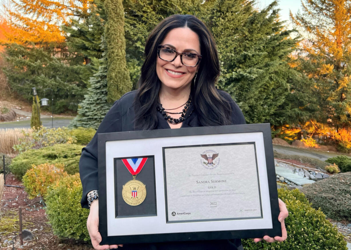 Sandra Sermone poses with the Presidential Award she recently received due to her work trying to cure her son's rare brain disease.