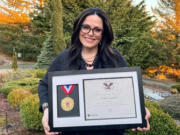 Sandra Sermone poses with the Presidential Award she recently received due to her work trying to cure her son's rare brain disease.