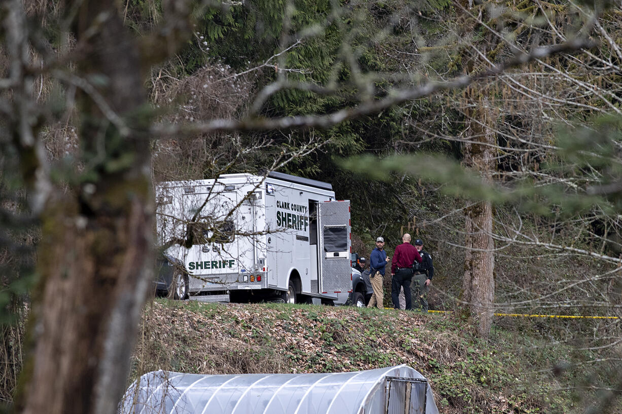 Law enforcement officials work at the scene along Wooding Road east of Washougal on Wednesday afternoon, March 22, 2023. Authorities found two bodies believed to be those of a missing Vancouver woman and her 7-year-old daughter in a brushy area farther down Wooding Road.