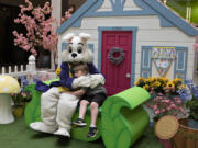 The Easter Bunny shares some love with Troy Allen Raye, 6, of Vancouver as they pose for some fun photos Monday afternoon at Vancouver Mall. At top, the Easter Bunny's energetic demeanor attracted children who ran down the hallway for a chance to give the bunny a high-five.