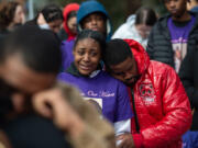 Layla Stewart's auntie, Lashay Taylor, in purple memorial shirt, grieves at a community vigil Sunday for the 7-year-old girl and her mother, Meshay Melendez, in Esther Short Park.