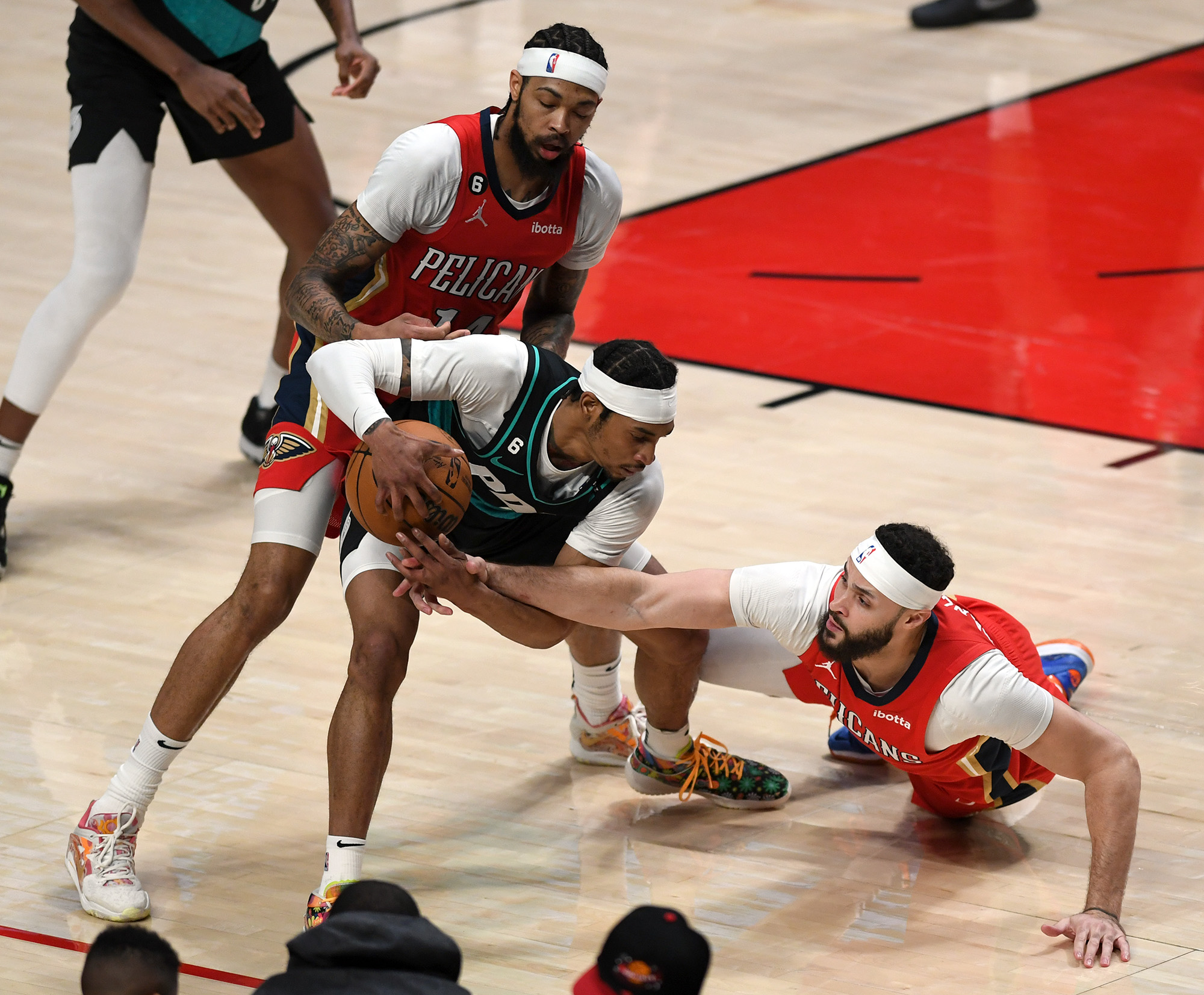 Portland shooting guard Keon Johnson, center, tries to keep the ball away from New Orleans small forward Brandon Ingram, left, and a diving Larry Nance Jr., right, on Monday, March 27, 2023, during the Trail Blazers’ 124-90 loss to the Pelicans at Moda Center.