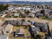 Floodwaters surround homes and vehicles in the community of Pajaro in Monterey County, Calif., on Monday, March 13, 2023.