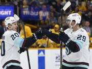 Seattle Kraken right wing Eeli Tolvanen (20) celebrates with defenseman Vince Dunn (29) after scoring a goal against the Nashville Predators during the first period of an NHL hockey game Saturday, March 25, 2023, in Nashville, Tenn.