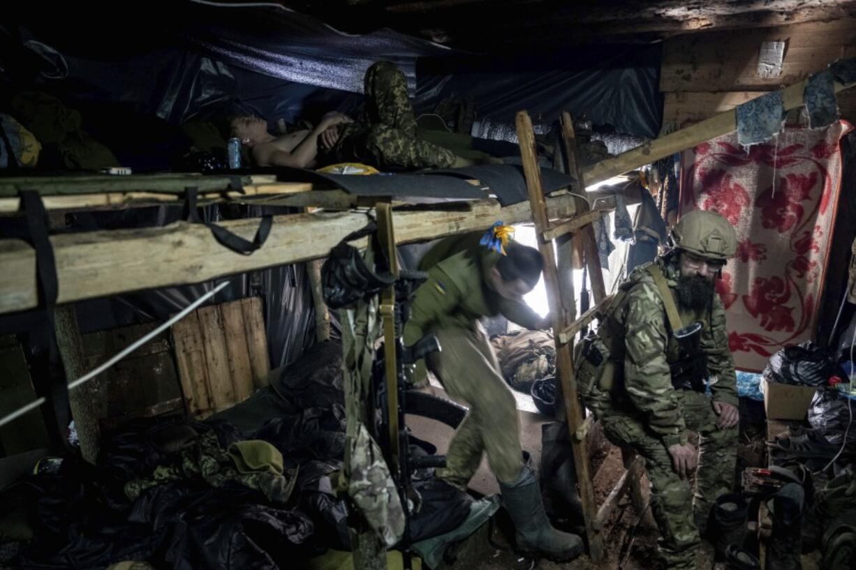 Ukrainian paratroopers of 80 Air Assault brigade rest inside a dugout at the frontline near Bakhmut, Ukraine, Friday, March 10, 2023.