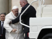 Pope Francis is helped into his car at the end of the weekly general audience in St. Peter's Square, at the Vatican, Wednesday, March 29, 2023. Pope Francis went to a Rome hospital on Wednesday for some previously scheduled tests, slipping out of the Vatican after his general audience and before the busy start of Holy Week this Sunday.