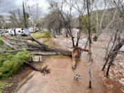 A creek running alongside an RV park rises with heavy rain and runoff Wednesday, March 22, 2023, near Cornville, Ariz. Several water rescues were reported across central and northern Arizona on Wednesday.