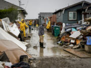 Miguel Rodriguez, 30, clears mud from his parents' home Tuesday  in Pajaro, Calif. (Bront?