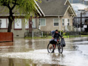 Erik Narez walks through floodwaters while leaving his home in the community of Pajaro in Monterey County, Calif., on Monday, March 13, 2023.