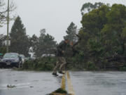 A tree downed by high winds blocks Webster Street in Oakland, Calif., Tuesday, March 21, 2023. (AP Photo/Godofredo A.