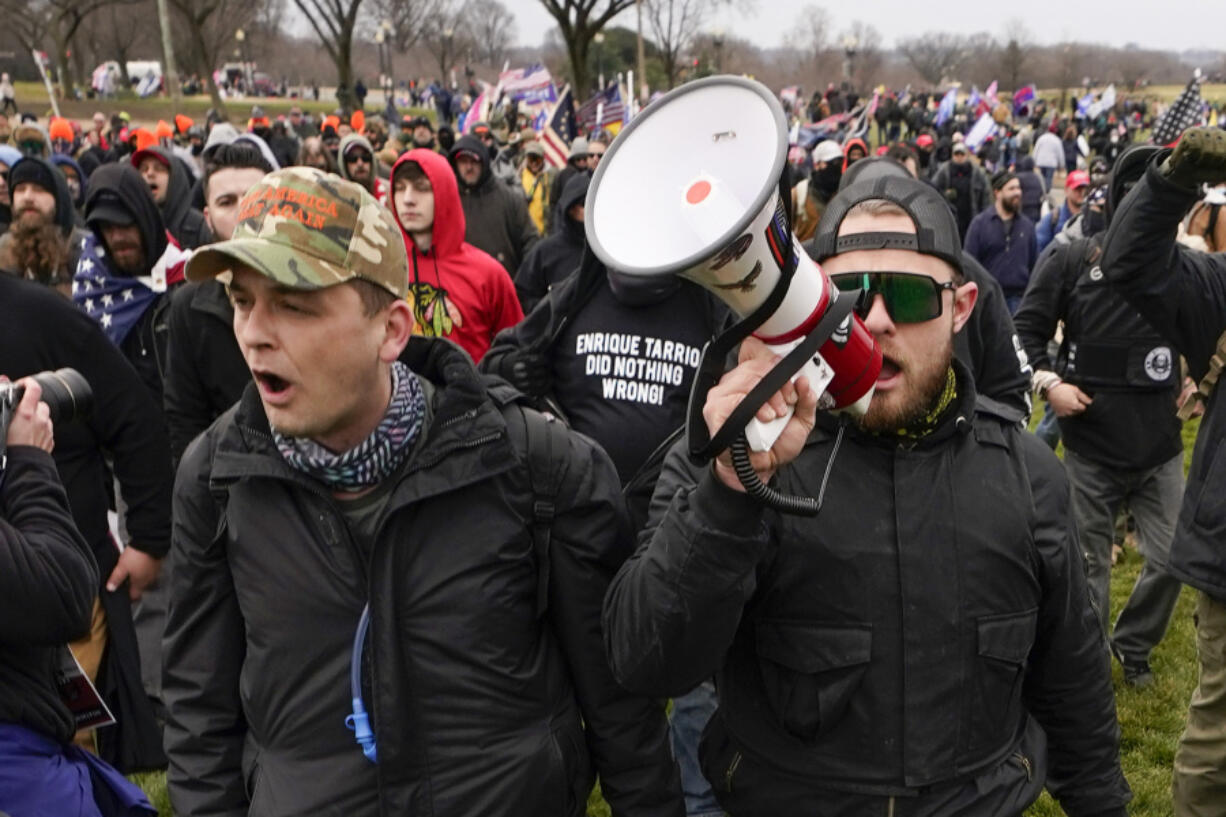 FILE - Proud Boys members Zachary Rehl, left, and Ethan Nordean, walk toward the U.S. Capitol in Washington, in support of President Donald Trump, Jan. 6, 2021. Federal prosecutors disclosed Wednesday, March 22, 2023, that a witness expected to testify for the defense at the seditious conspiracy trial of former Proud Boys leader Enrique Tarrio and four associates was secretly acting as a government informant for nearly two years after the Jan. 6 attack on the U.S. Capitol, a defense lawyer said in a court filing.