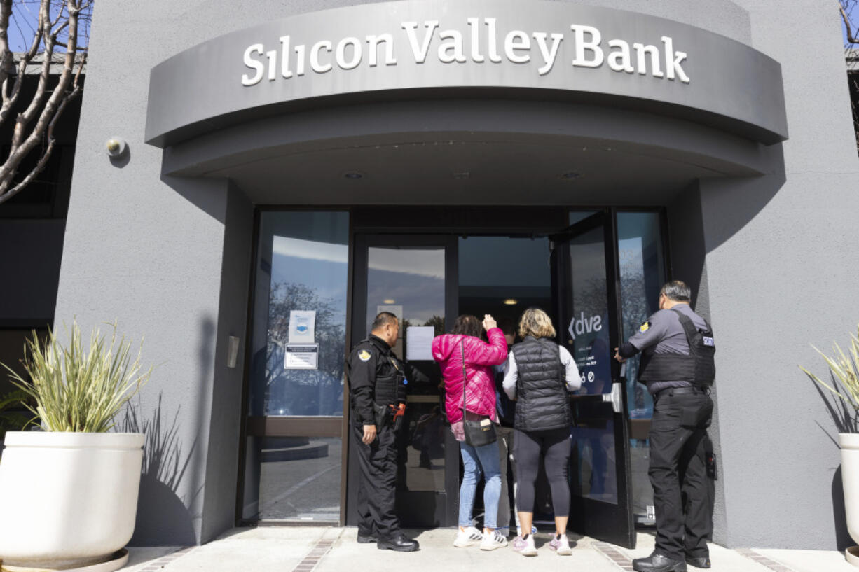 FILE - Security guards let individuals enter the Silicon Valley Bank's headquarters in Santa Clara, Calif., March 13, 2023. Lawmakers are up in arms over the collapse of Silicon Valley Bank and Signature Bank, and they're questioning what went wrong. But while President Joe Biden has urged Congress to strengthen the rules for banks to prevent more failures, lawmakers are divided on legislation.