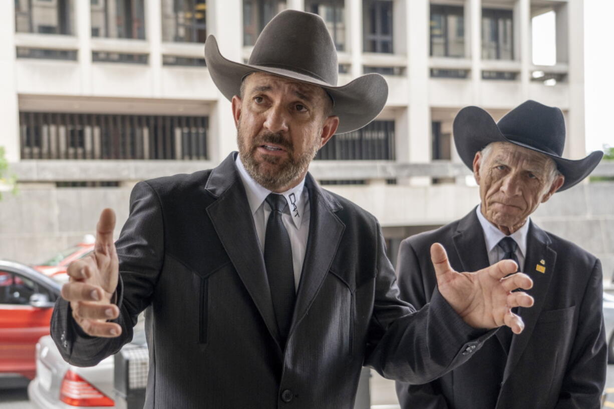 FILE - Otero County, New Mexico Commissioner Couy Griffin speaks to reporters as he arrives at federal court in Washington, June 17, 2022. A jury will consider this week whether the support group Cowboys for Trump and cofounder Couy Griffin violated state election law by failing to register as a political organization without filing related public financial disclosures. A two-day trial was scheduled to start Tuesday, Feb. 28, 2023, in Alamogordo, N.M.