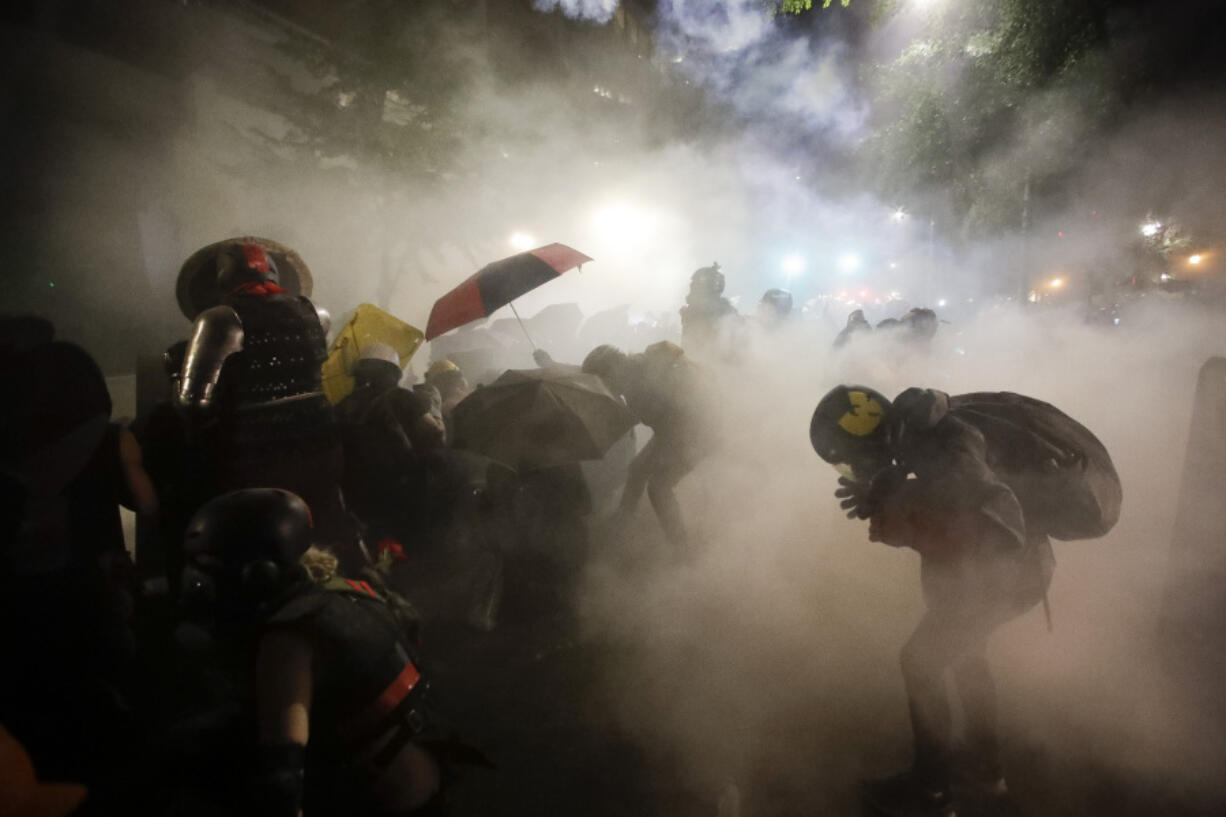 FILE - Federal officers launch tear gas at a group of demonstrators during a Black Lives Matter protest at the Mark O. Hatfield United States Courthouse in Portland, Ore., on July 26, 2020. More than 119,000 people have been injured by tear gas and other chemical irritants around the world since 2015 and some 2,000 suffered injuries from "less lethal" impact projectiles, according to a new report released Wednesday, March 22, 2023.