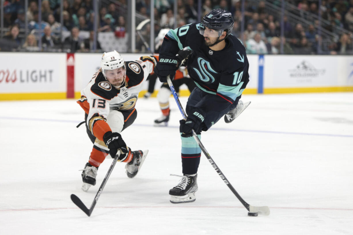 Seattle Kraken center Matty Beniers (10) shoots as Anaheim Ducks defenseman Simon Benoit (13) defends during the fist period of an NHL hockey game Thursday, March 30, 2023, in Seattle.