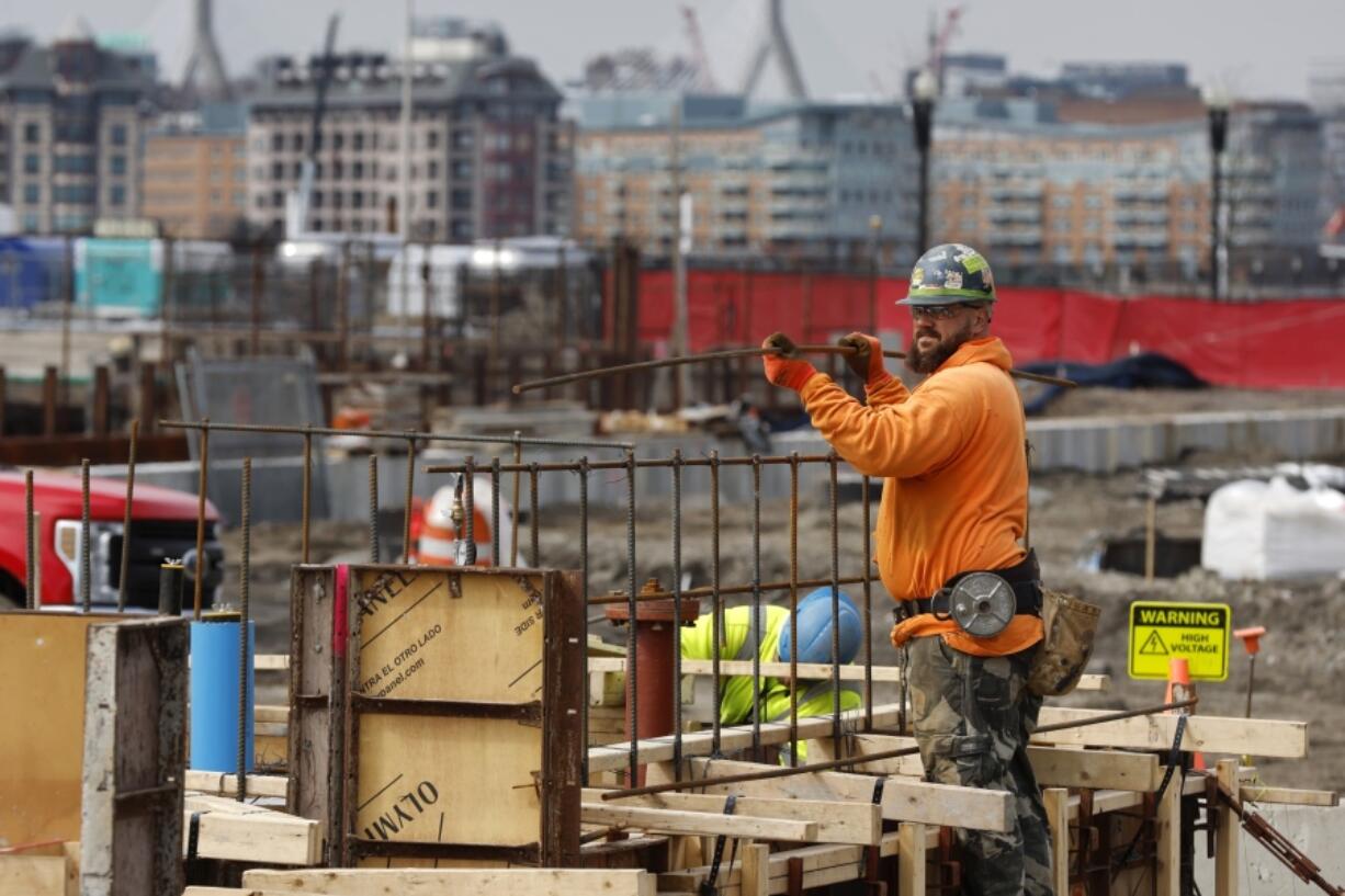 A construction worker prepares a recently poured concrete foundation, Friday, March 17, 2023, in Boston. On Thursday, the Commerce Department issues its third and final estimate of how the U.S.