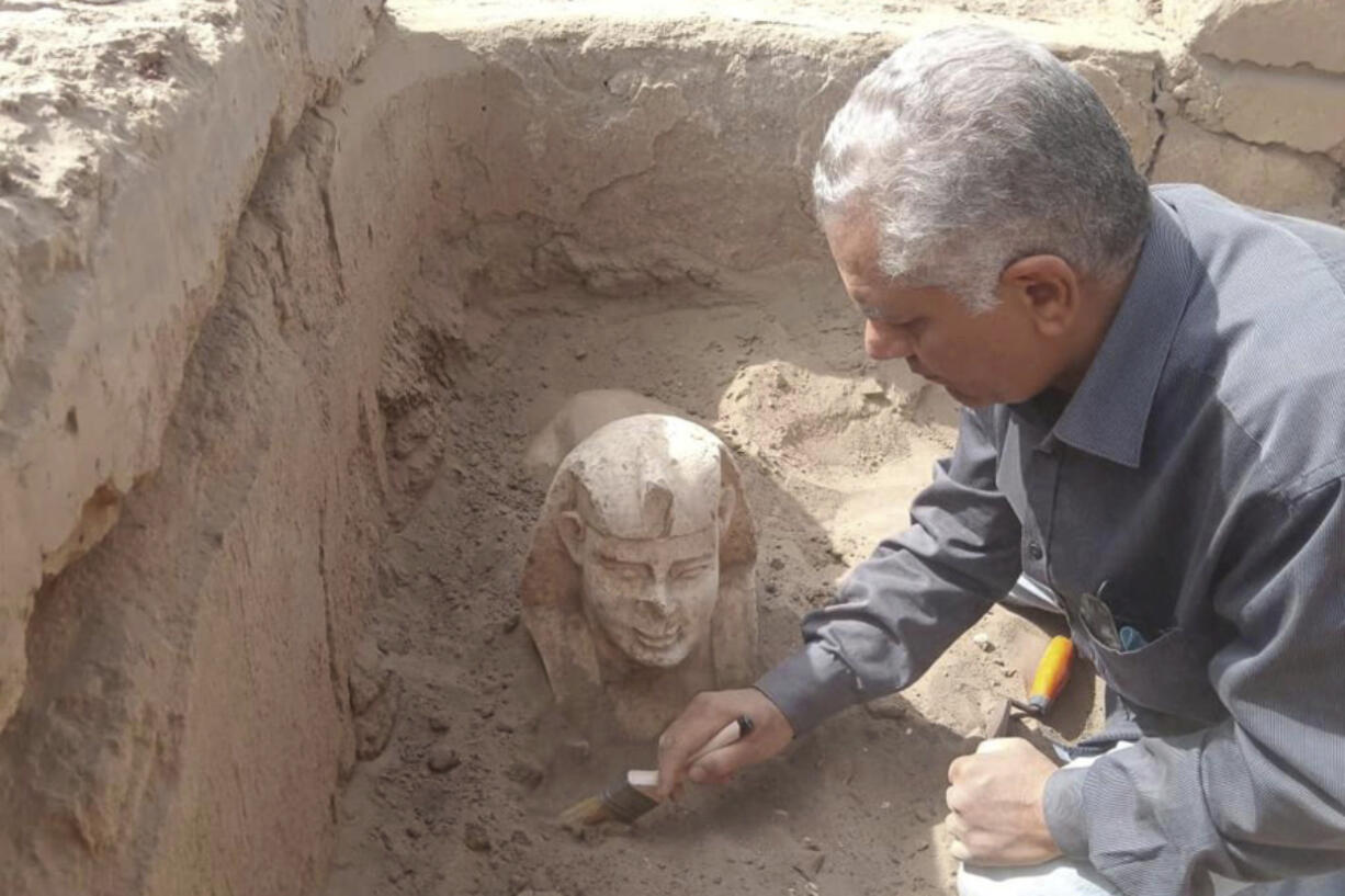 In this undated photo distributed Monday, March 6, 2023, by the Egyptian Ministry of Tourism and Antiquities, a sphinx statue believed to be made in the likeness of a Roman emperor is uncovered from an archaeological site in Qena, Egypt. The site that also contains a shrine to the Ancient Egyptian god Horus dating back to the Roman era, according to the country's top antiquities official Mostafa Waziri. Waziri also said in a statement that initial examinations point to the statue being modeled after the Roman Emperor Claudius, who ruled in the first century AD.