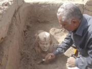 In this undated photo distributed Monday, March 6, 2023, by the Egyptian Ministry of Tourism and Antiquities, a sphinx statue believed to be made in the likeness of a Roman emperor is uncovered from an archaeological site in Qena, Egypt. The site that also contains a shrine to the Ancient Egyptian god Horus dating back to the Roman era, according to the country's top antiquities official Mostafa Waziri. Waziri also said in a statement that initial examinations point to the statue being modeled after the Roman Emperor Claudius, who ruled in the first century AD.