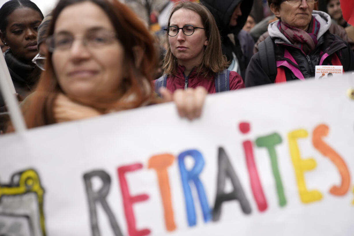 People march during a demonstration Tuesday, March 28, 2023 in Paris. It's the latest round of nationwide demonstrations and strikes against unpopular pension reforms and President Emmanuel Macron's push to raise France's legal retirement age from 62 to 64.