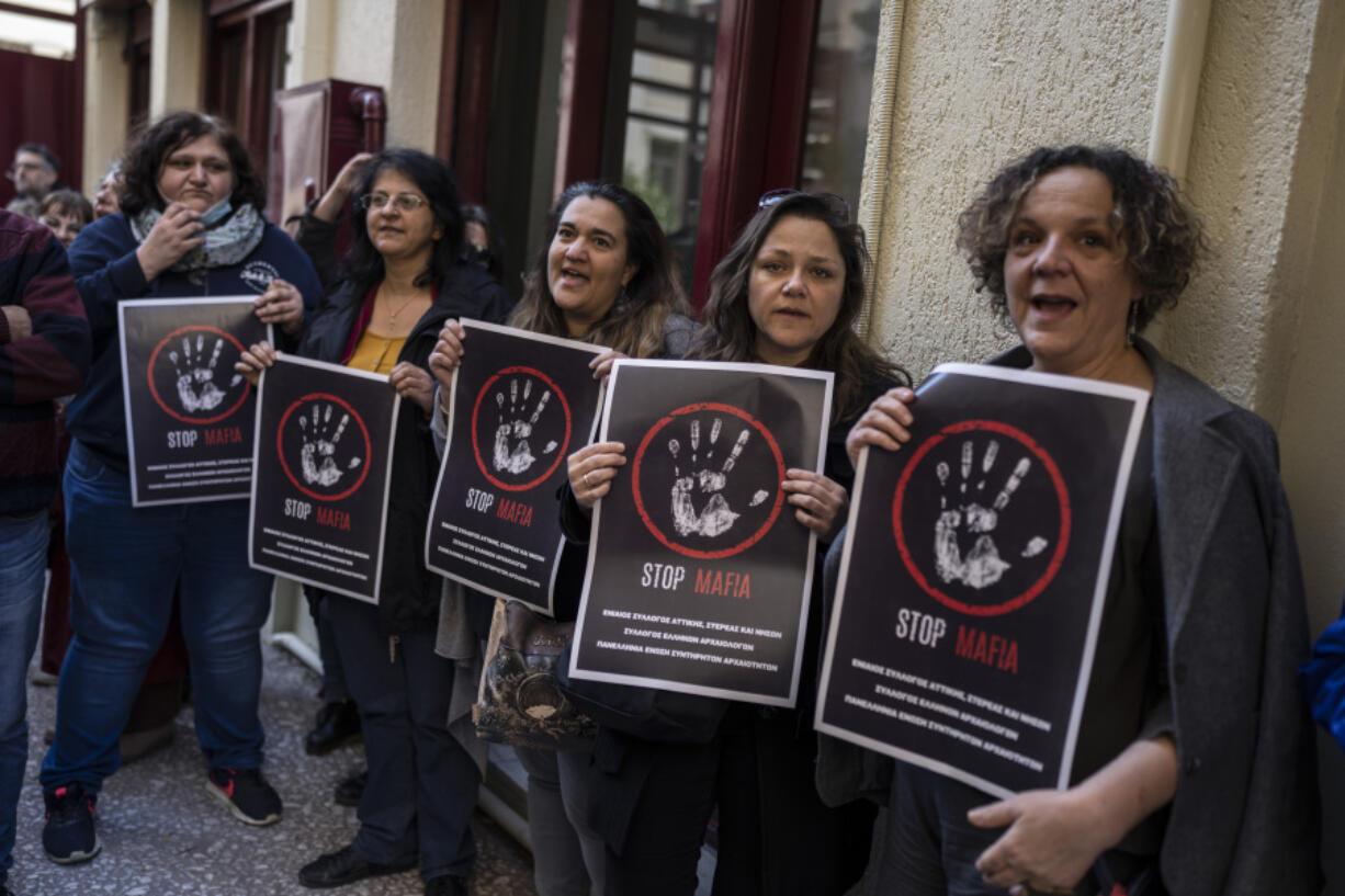 State-employed archaeologists in Greece hold placards as they launched strike action outside the Culture Ministry in Athens, on Tuesday, March 14, 2023, to protest the assault of an archaeologist on the island of Mykonos, in an attack they say may have been linked to commercial pressure to extend tourism development. Archaeologist Manolis Psarros was beaten by two unidentified men on the island last week and was left unconscious and bleeding in the street.