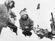 FILE - Rescue workers recover a body April 2, 1982, buried in the parking lot of the Alpine Meadows ski resort after an avalanche that killed seven people rolled through the area in the Sierra Nevada mountains near Palisades Tahoe, Calif. The Alpine avalanche on March 31, 1982, was the deadliest avalanche to sweep through a ski area. Since December 2022, a parade of a dozen atmospheric storms have dumped so much snow up and down the Sierra that several ski resorts around Lake Tahoe have had to shut down multiple times.