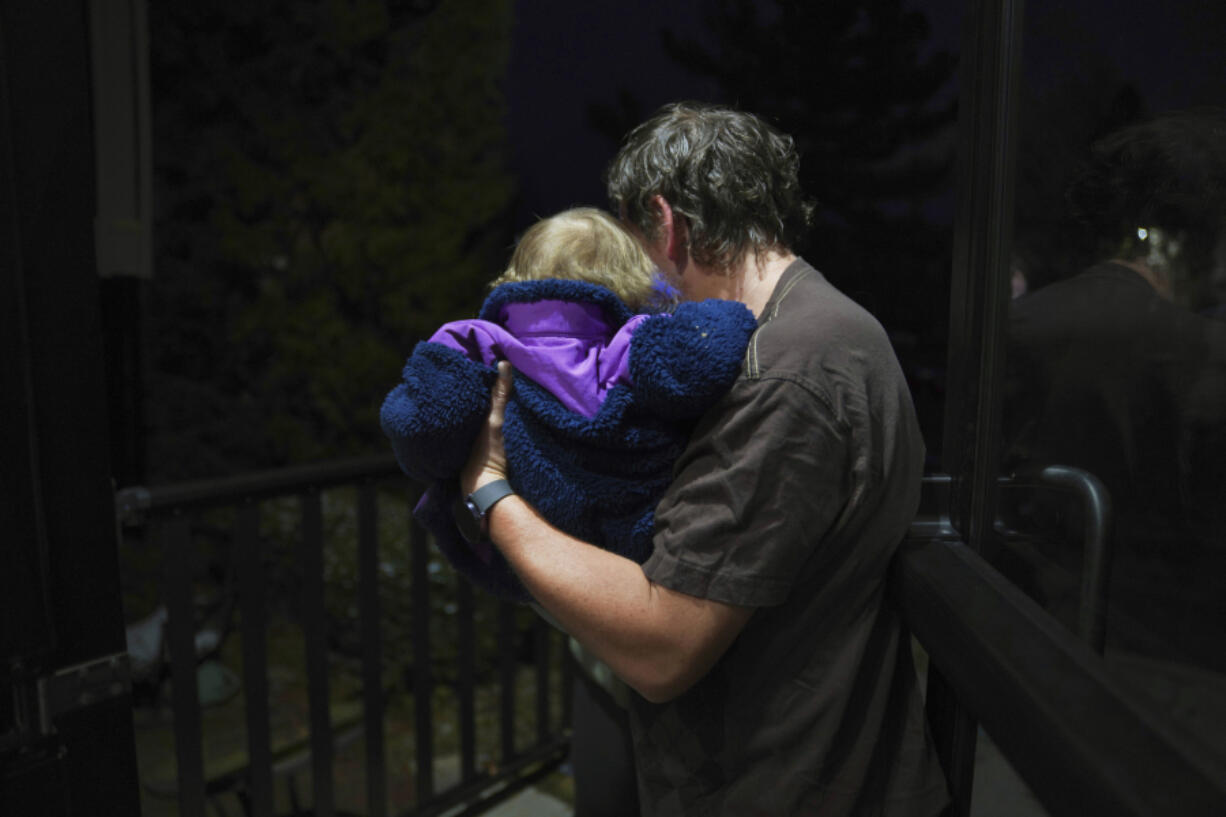 Andrew Hackney hands his 1-year-old daughter back to the Office of Children, Youth and Families services at the end of one of their twice weekly supervised visits in Oakdale, Pa., on Thursday, Nov. 17, 2022. At 7 months old, Andrew and his wife, Lauren, had difficulty feeding their daughter and brought her to the children's hospital in Pittsburgh. They believe hospital staff alerted the Allegheny County Department of Human Services because the baby was severely dehydrated and malnourished, which resulted in removing the young child from their custody. The Hackneys and their lawyer believe the Allegheny County Family Screening artificial intelligence tool may have flagged the couple as dangerous because of their disabilities.