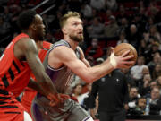 Sacramento Kings forward Domantas Sabonis, right, drives to the basket on Portland Trail Blazers forward Nassir Little, left, during the first half of an NBA basketball game in Portland, Ore., Wednesday, March 29, 2023.