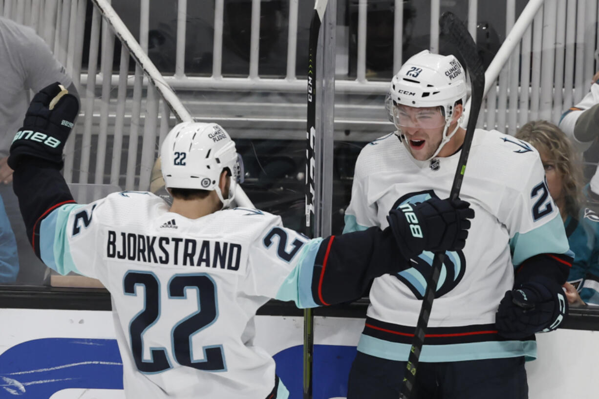 Seattle Kraken right wing Oliver Bjorkstrand (22) celebrates with defenseman Vince Dunn (29), who scored an overtime goal against the San Jose Sharks in an NHL hockey game in San Jose, Calif., Thursday, March 16, 2023.