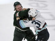 Minnesota Wild center Mason Shaw, left, and Seattle Kraken left wing Yanni Gourde fight during the third period of an NHL hockey game Monday, March 27, 2023, in St. Paul, Minn. Both drew major penalties for fighting.