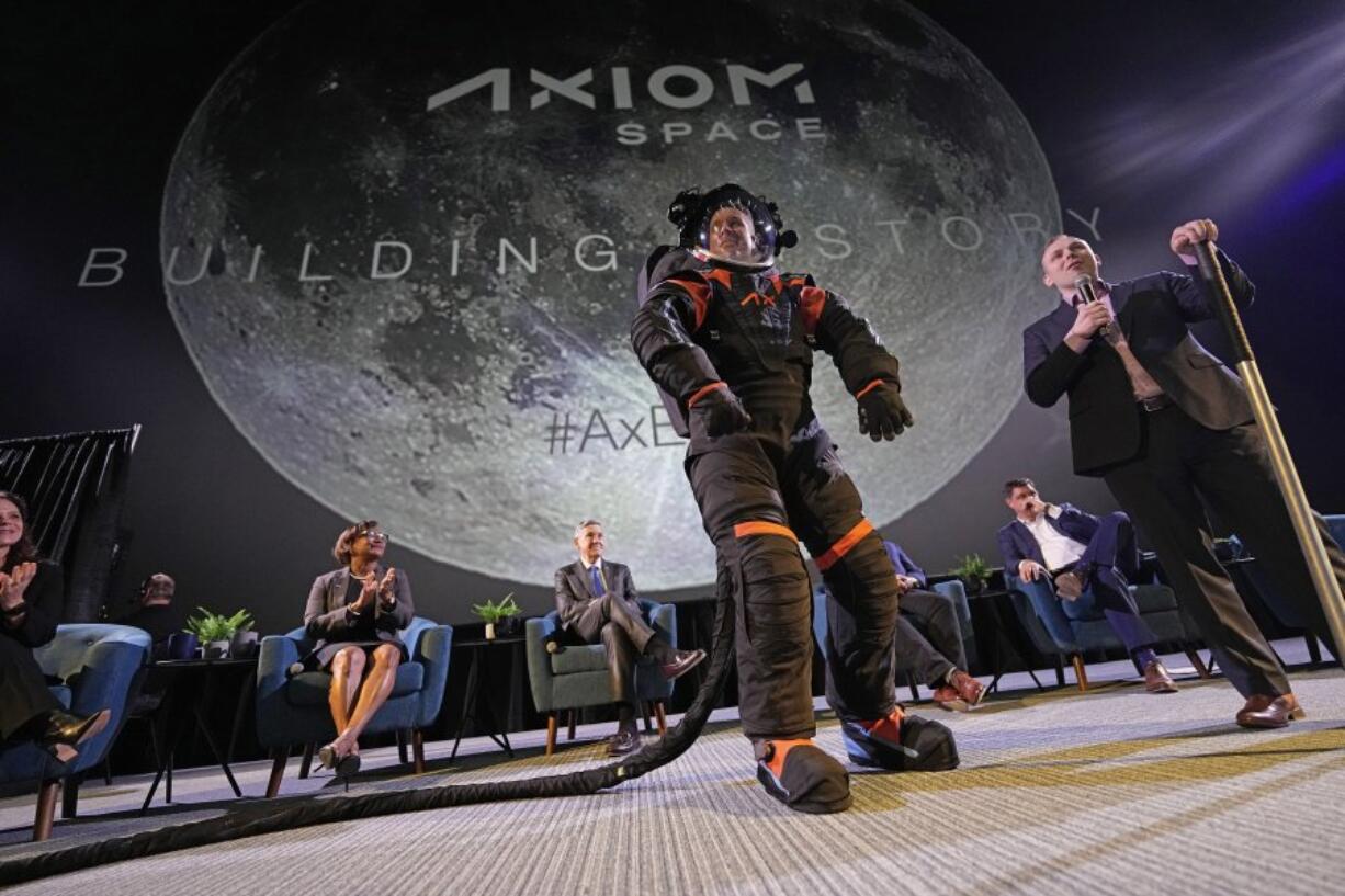 Axiom Space chief engineer Jim Stein, left, demonstrates a prototype spacesuit Wednesday as deputy manager for extravehicular activity Russell Ralston explains features of the spacesuit in Houston (David J.