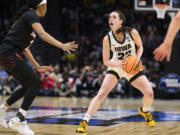 Iowa guard Caitlin Clark (22) steps back before shooting a 3-point basket as Louisville guard Morgan Jones (24) closes in on defense during the second quarter of a Sweet 16 college basketball game of the NCAA Tournament in Seattle, Sunday, March 26, 2023.