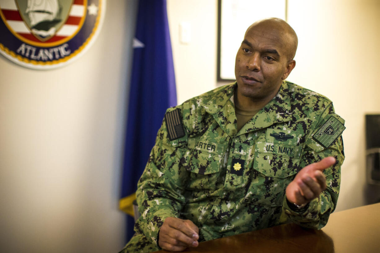 Navy Chaplain Lt. Cmdr. Madison Carter, the head chaplain for Destroyer Squadron 28, home ported at Norfolk Naval Station in Norfolk, Va. speaks about his role as a Navy chaplain on Tuesday, March 14, 2023. Carter, a Baptist pastor, says the vast majority of his talks with sailors involve not faith but life struggles that can make them feel unfulfilled and lose focus. "How do I make sure that you have mind, body and soul all locked in?" is the question that drives his mission. (AP Photo/John C.