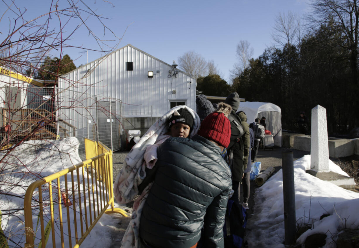 Haitian and Afghani asylum seekers illegally cross into Canada where police took them into custody at the non-official Roxham Road border crossing north of Champlain, New York, on Friday, March 24, 2023. A new US-Canadian migration agreement closes a loophole that has allowed migrants who enter Canada away from official border posts to stay in the country while awaiting an asylum decision.