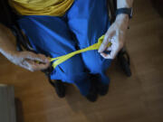 Alex Morisey does his afternoon exercises using a resistance band in his room at a nursing home in Philadelphia, on Wednesday, Feb. 15, 2023. He ended up in a nursing home after a fall and, once here, learned his income would no longer be his. Pennsylvania's allowance is $45, and after a monthly $20 haircut and $5 tip, a juggling act begins.