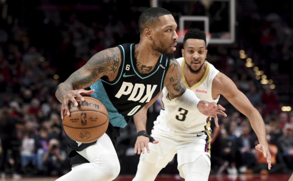 Portland Trail Blazers guard Damian Lillard, left, drives to the basket against New Orleans Pelicans guard CJ McCollum during the first half of an NBA basketball game in Portland, Ore., Wednesday, March 1, 2023.