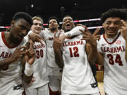 Alabama players celebrate on the court after an NCAA college basketball game against Texas A&M in the finals of the Southeastern Conference Tournament, Sunday, March 12, 2023, in Nashville, Tenn.