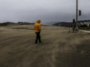 A man walks through a windstorm at Ocean Beach on a stormy morning in San Francisco on Tuesday, March 14, 2023.