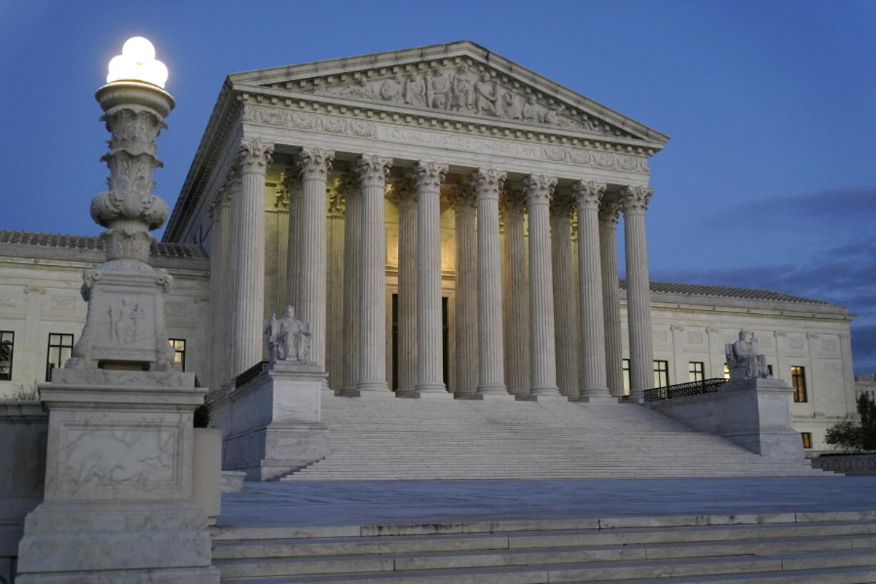 FILE - Light illuminates part of the Supreme Court building at dusk on Capitol Hill in Washington, Nov. 16, 2022.