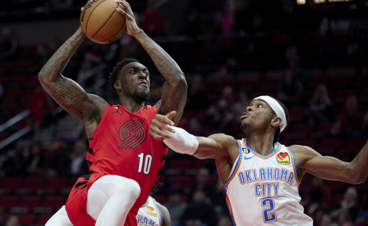 Portland Trail Blazers forward Nassir Little, left, looks to shoot over Oklahoma City Thunder guard Shai Gilgeous-Alexander during the second half of an NBA basketball game in Portland, Ore., Sunday, March 26, 2023.